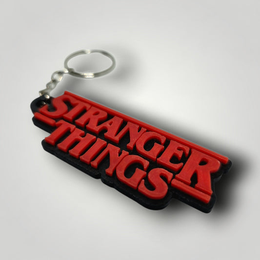 Detalle llavero Stranger Things logo rojo y negro impresión 3D con anilla metálica
